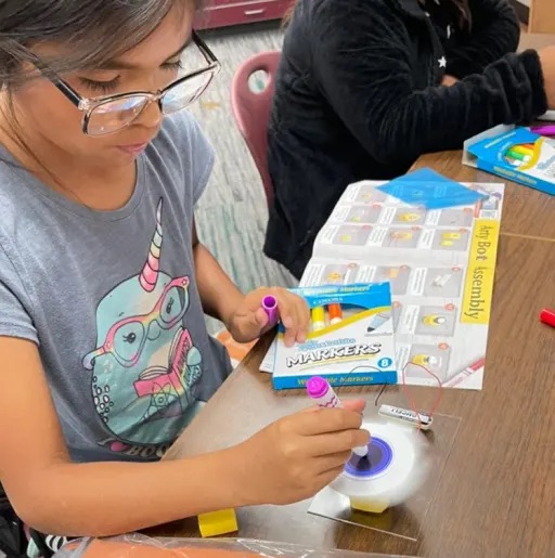 kid doing an activity in the classroom table 