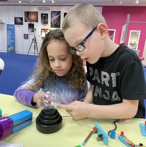 boy and a girl doing an activity together on a classroom table 