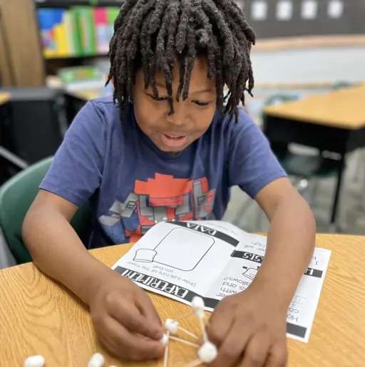 Kid writing in his book