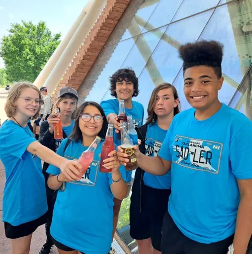 kids drinking watter from a glass bottler