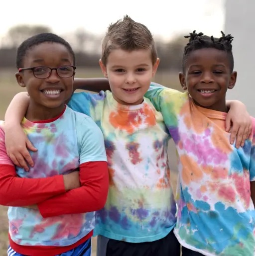 3 kids smiling at the camera