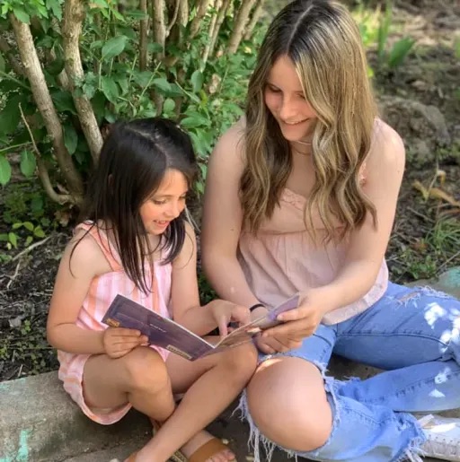 2 girls reading a book