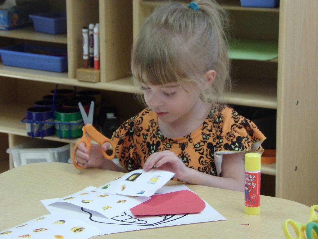 Preeschool student holing sissors