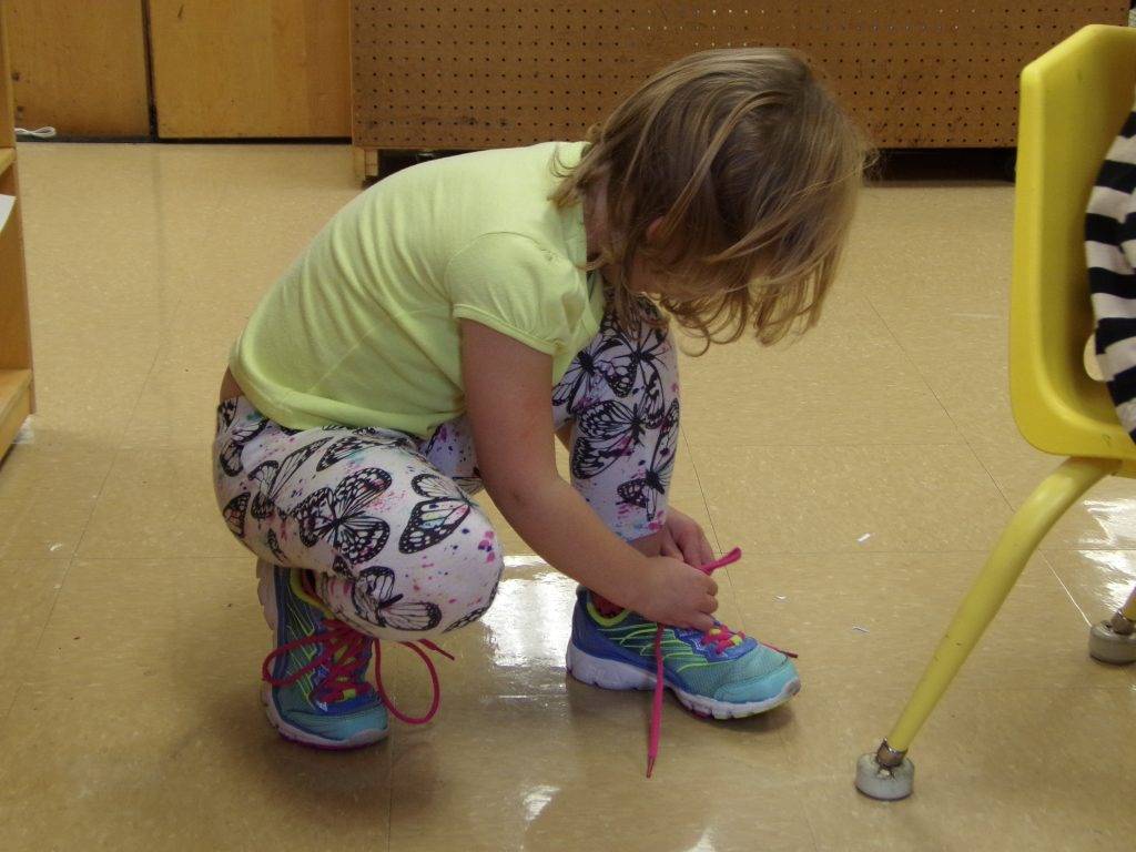 Preeschool student tying her shoes