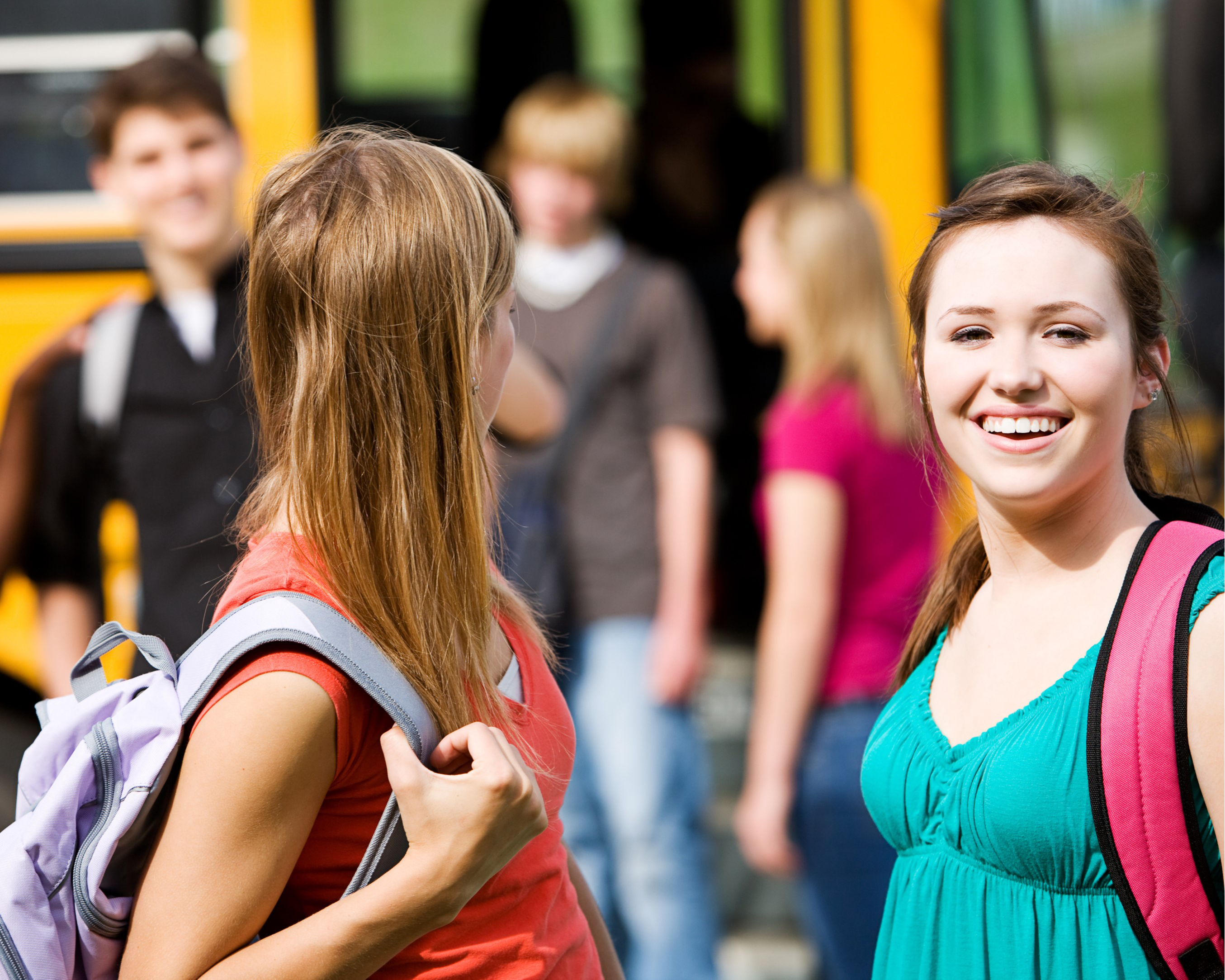 Teens in front of school bus