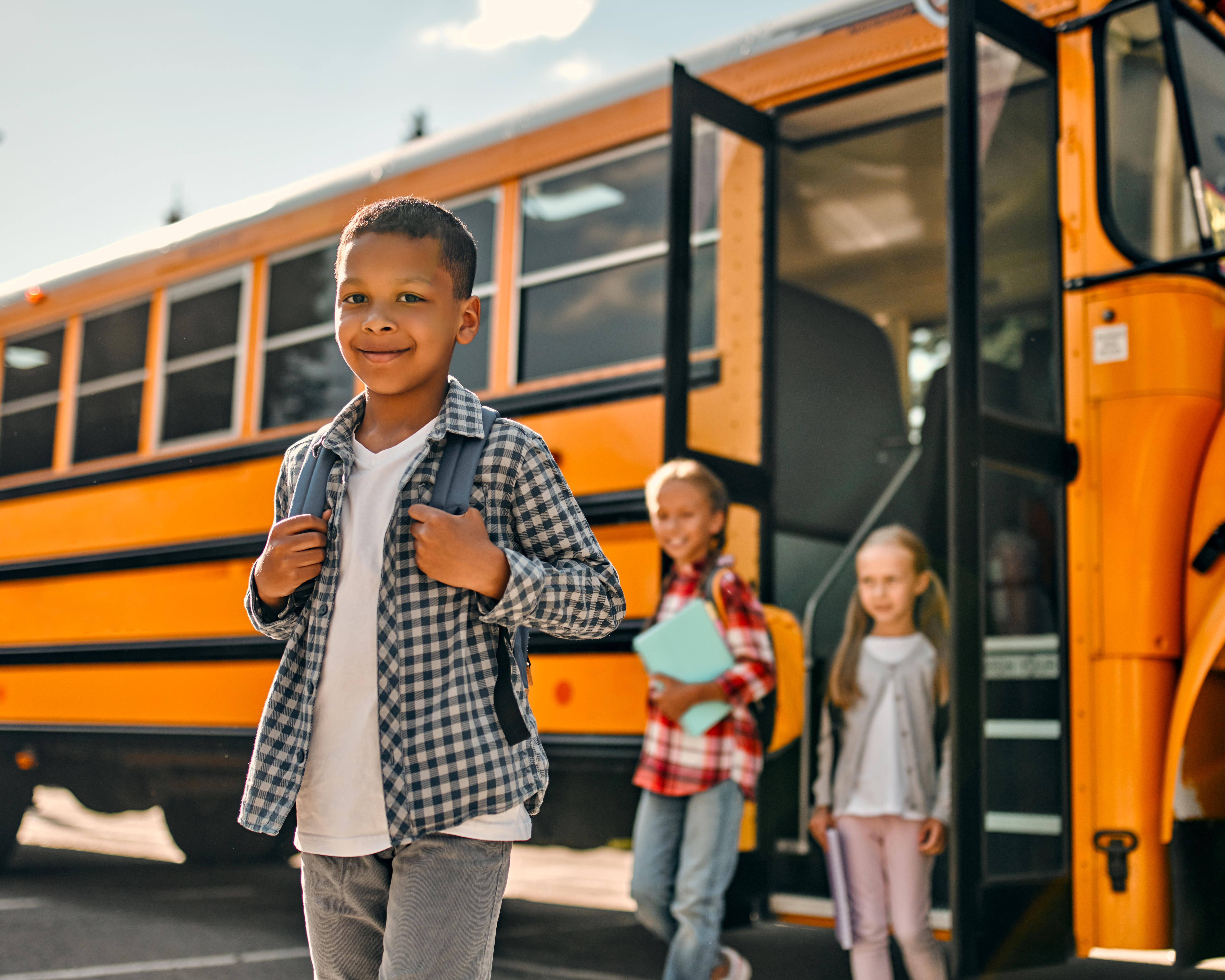 Boy getting off school bus smiling