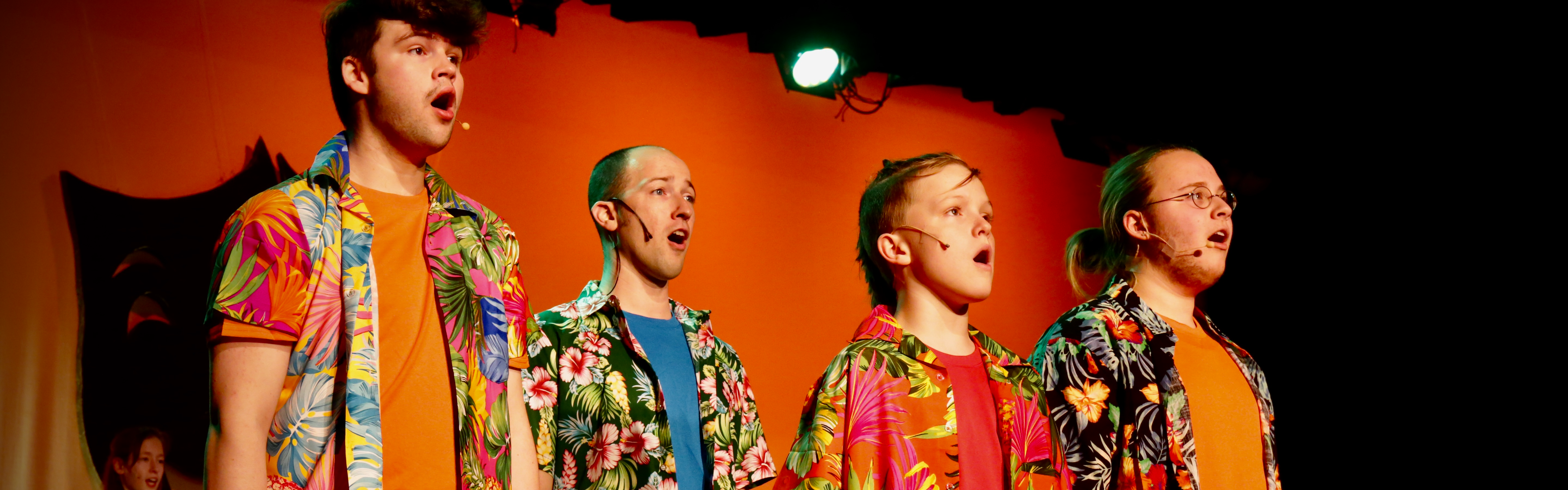 A group of men sings during a performance at the John Legend Theater