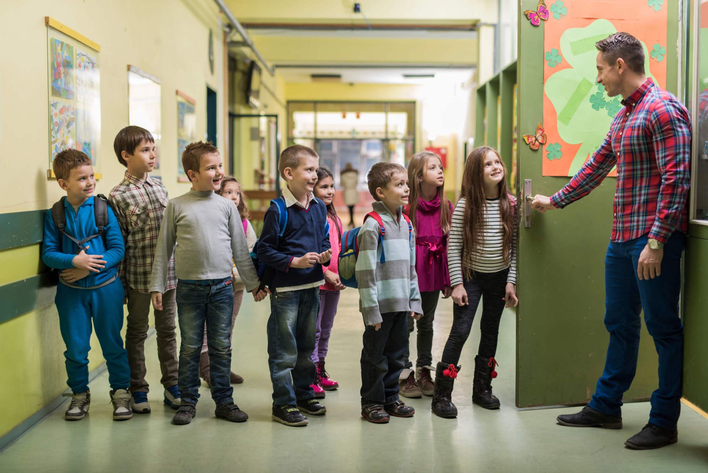 teacher and sutents smiling on a row at the school