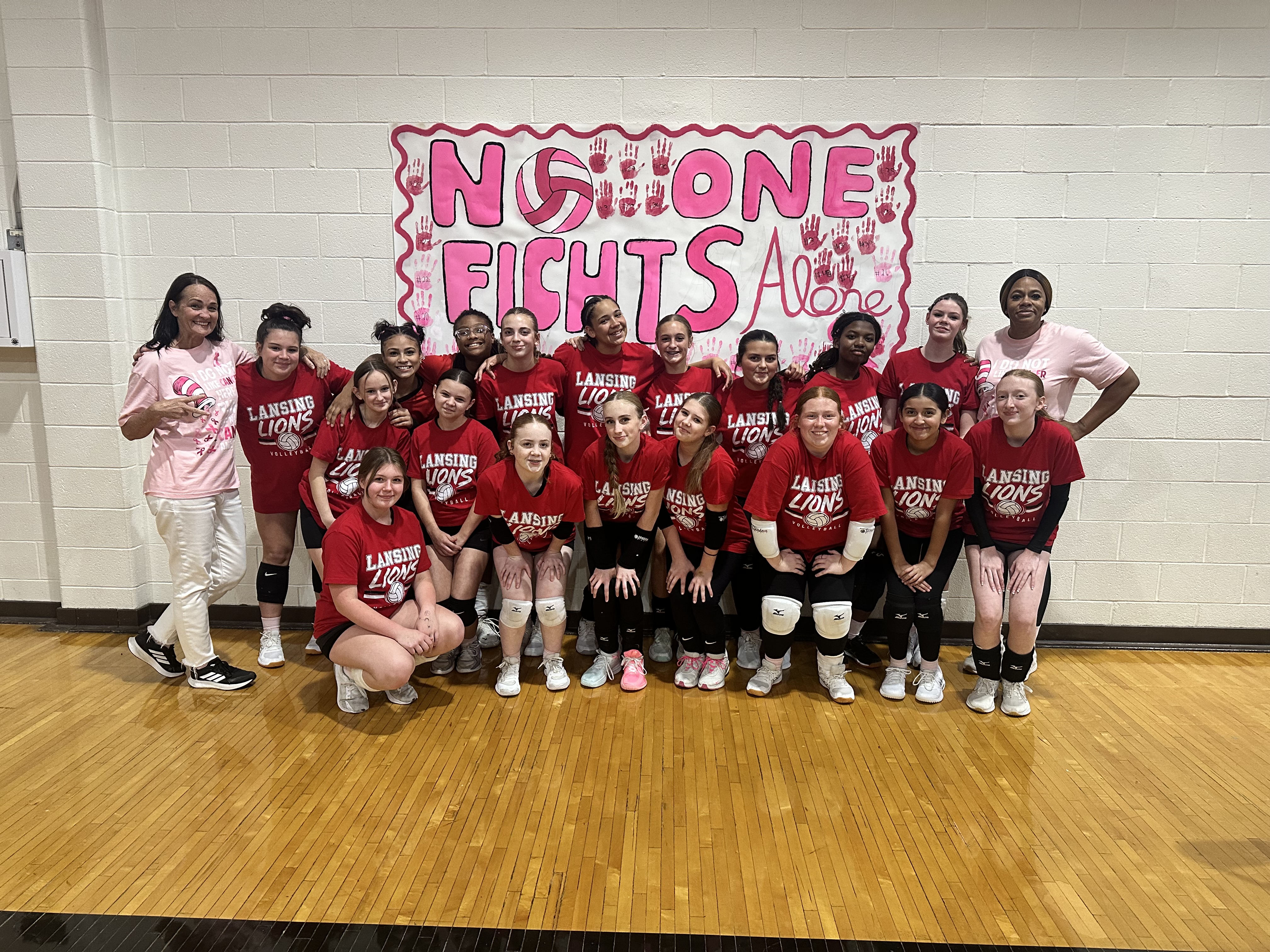Volleyball players posing at pink out game