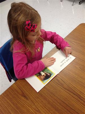 little girl in her desk, completing an activity