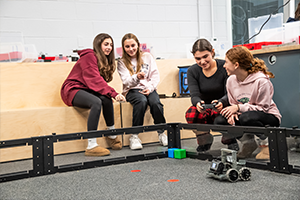 girls watching car robots move on the floor