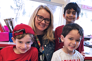 teacher posing with three kids