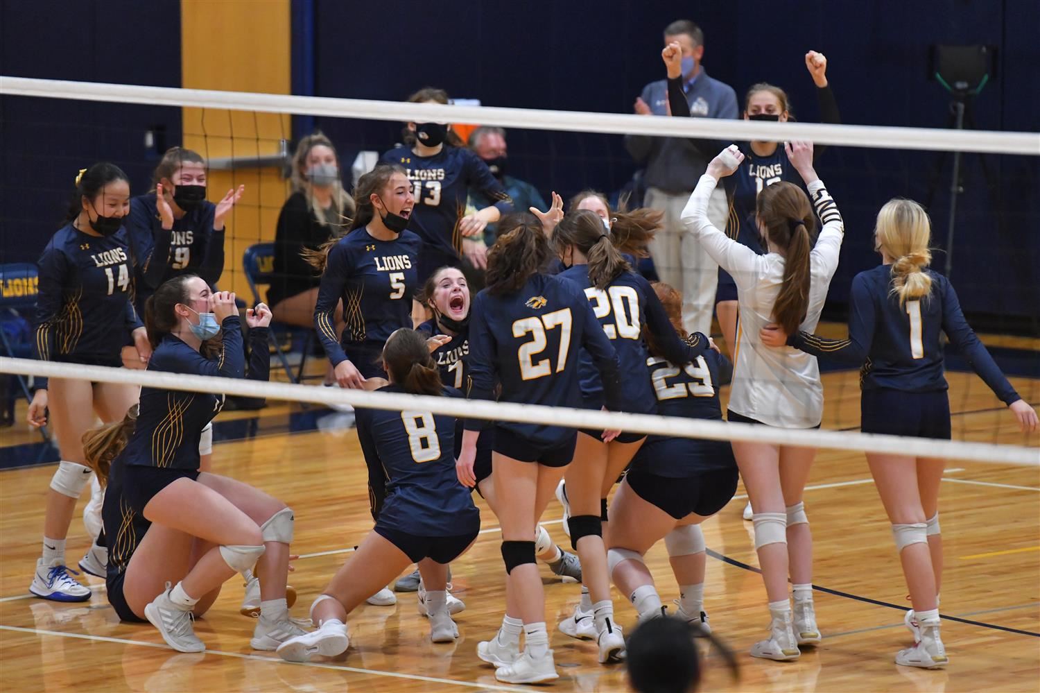 group of students celebrating a point in a voleyball match