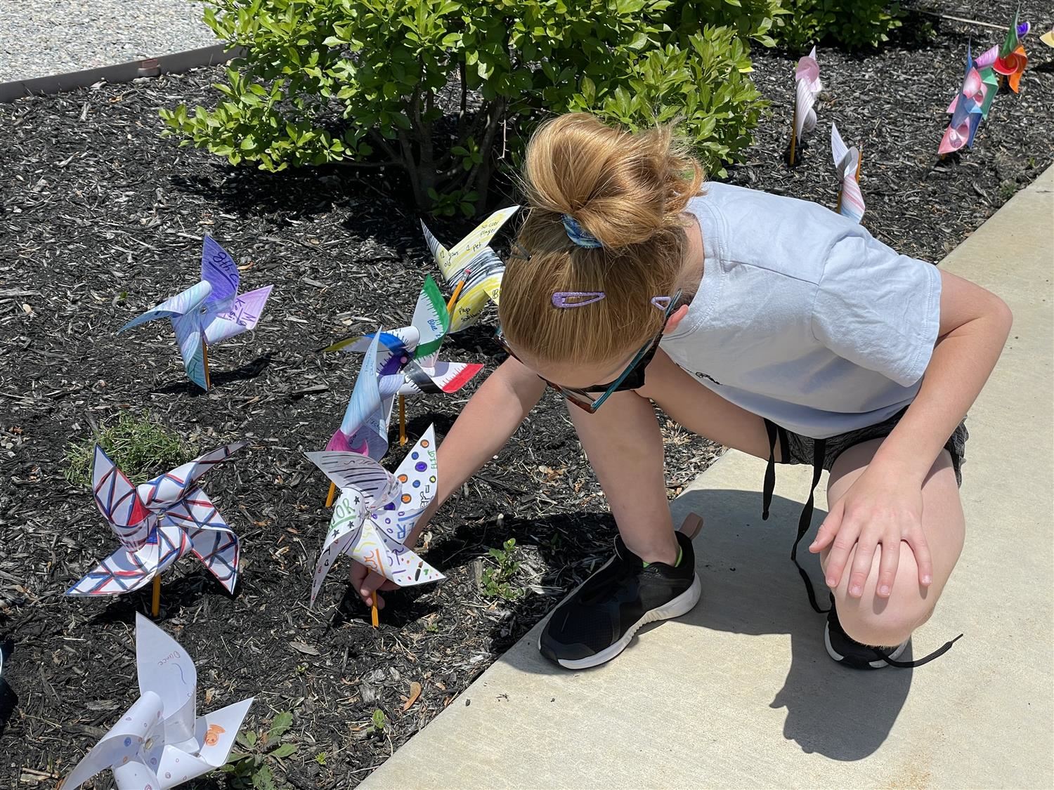 girl putting a paper swirl on the ground