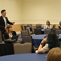 educators listening to initiatives on a room with tables and chairs