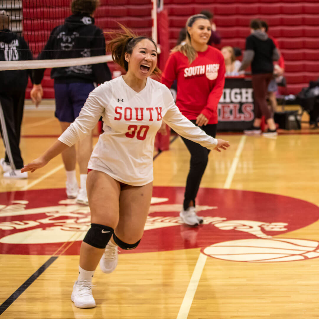 A volleyball player runs across the gym