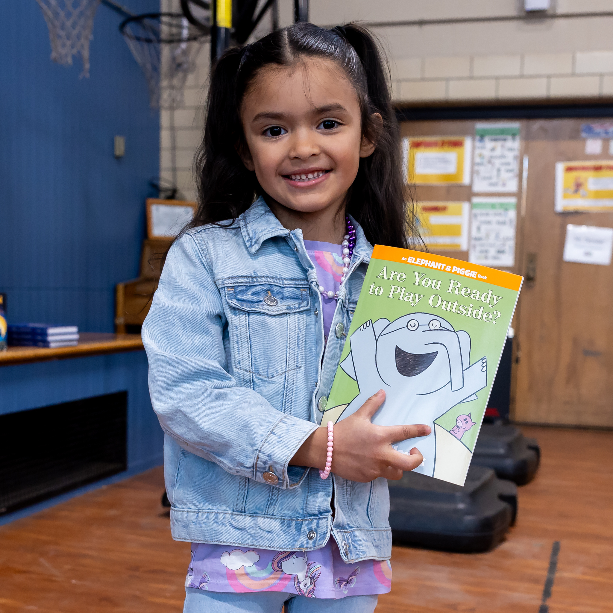 A young student holds up a book.