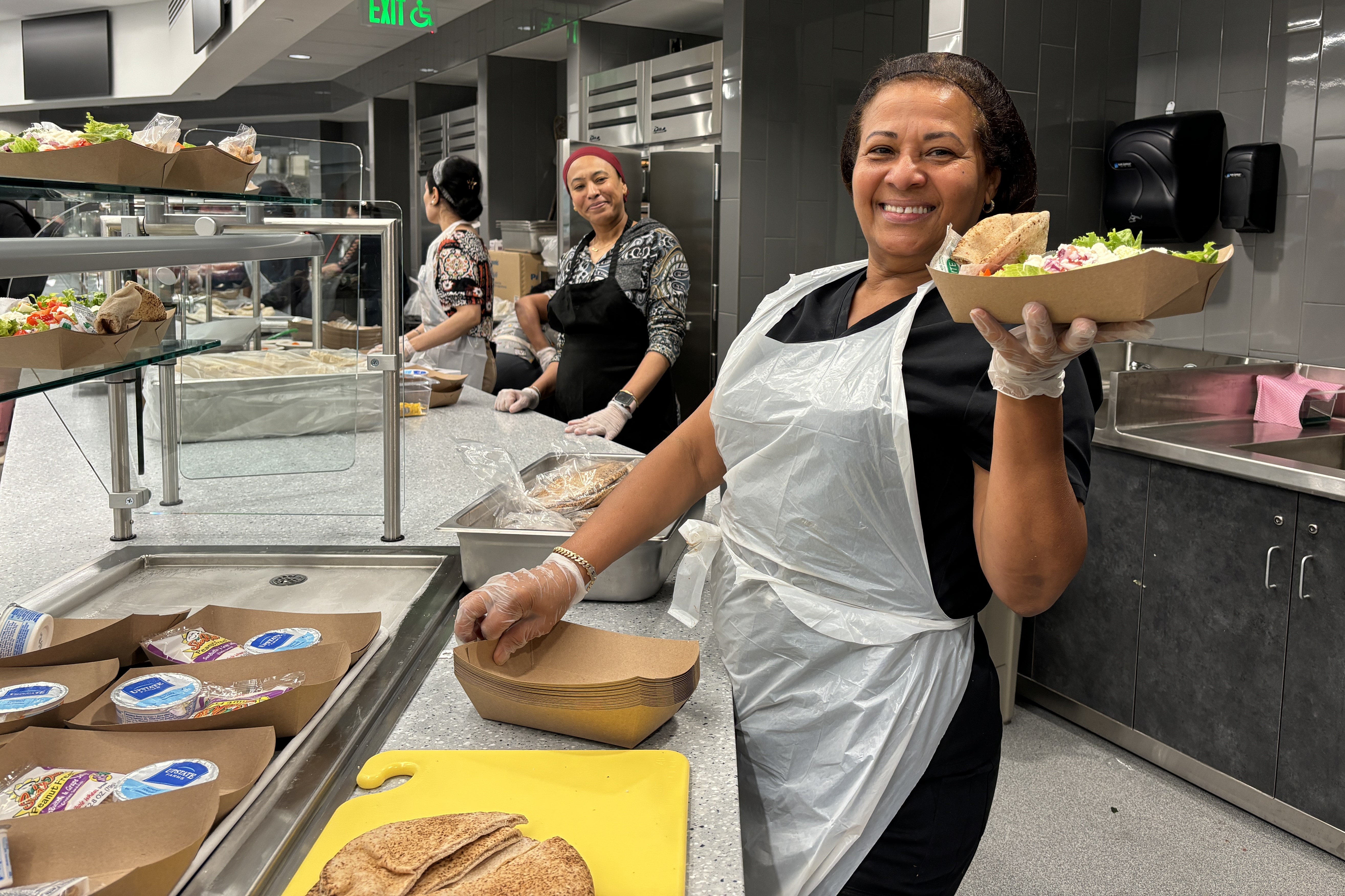 Cafeteria helper holding a tray with a single school lunch