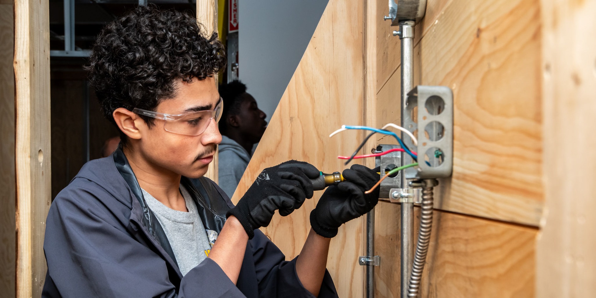 A student completes electrical work.