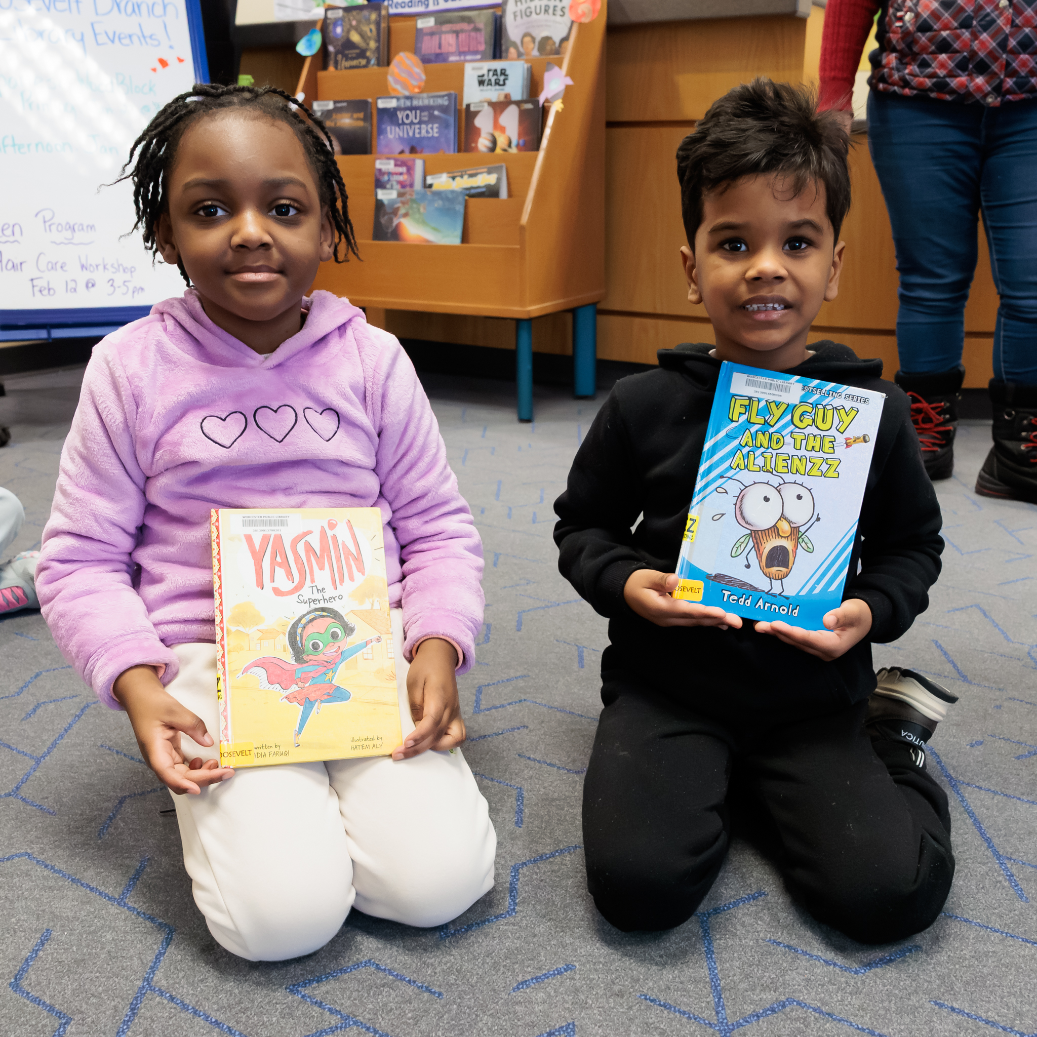 Two students from Roosevelt School hold books.