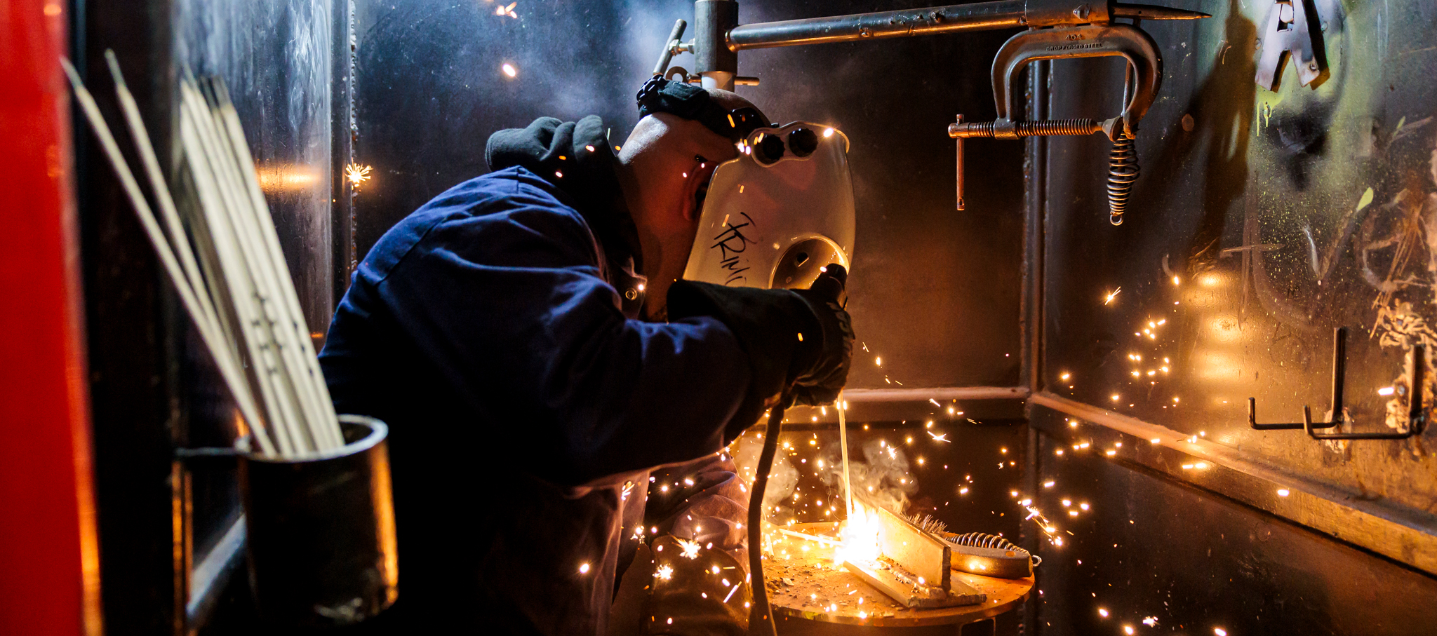 An adult education student practices welding during a class.