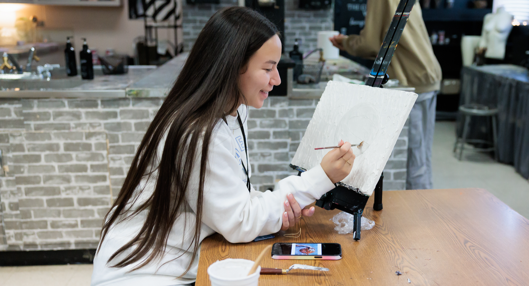 A student completes artwork in class.