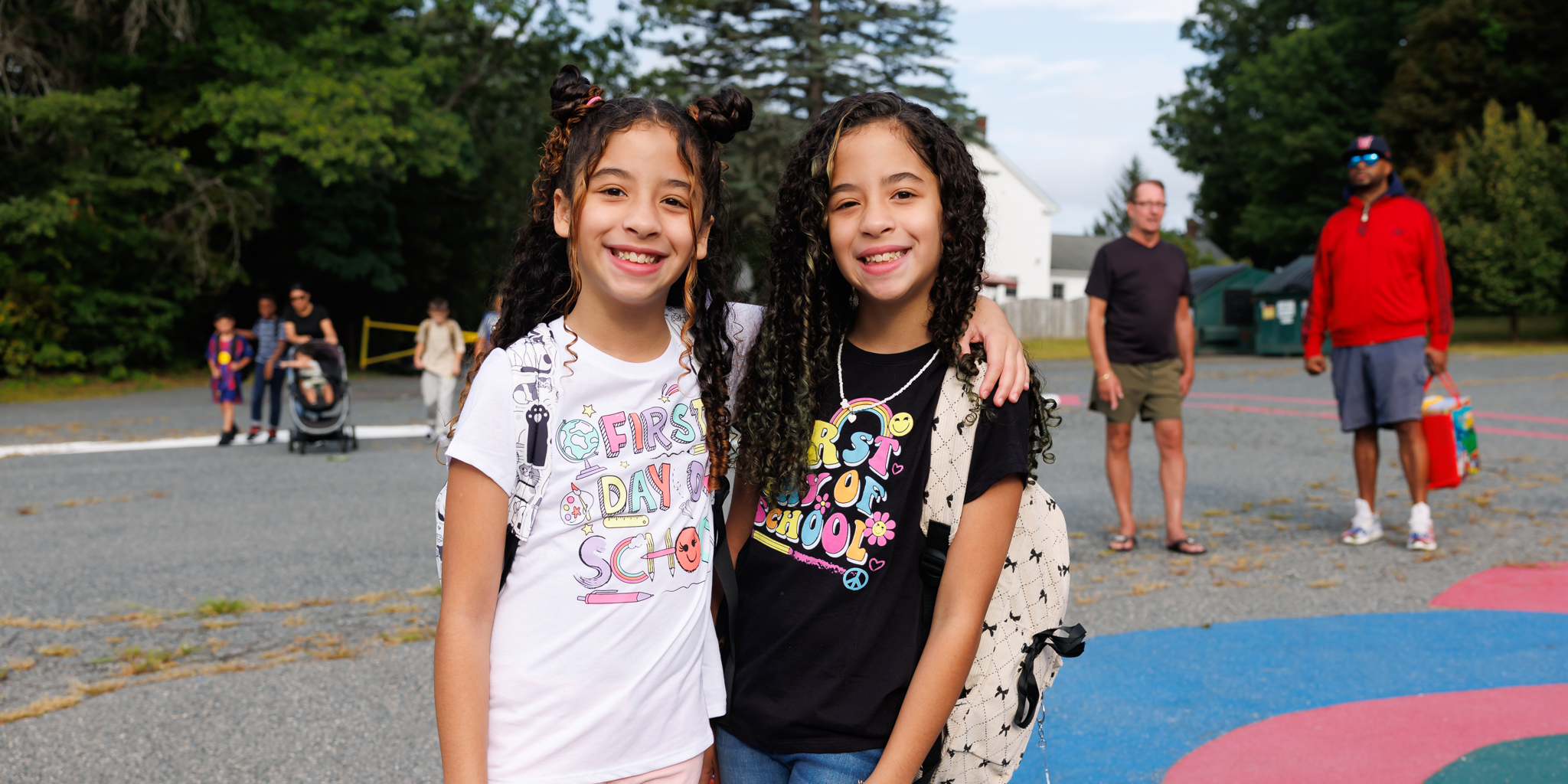 Two students stand together wearing shirts that say "First Day of School"