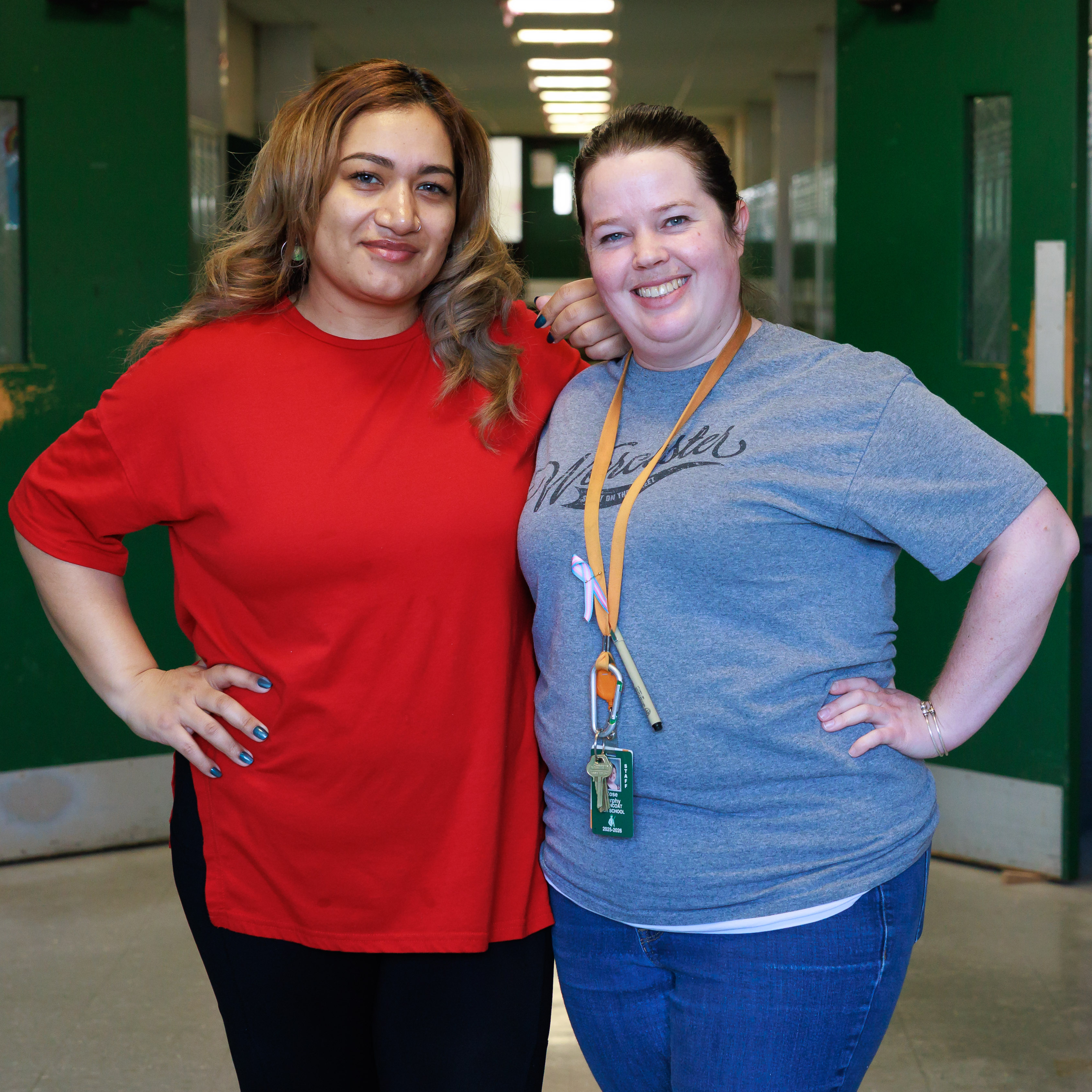 Two Worcester Public Schools employees stand together in a school hallway.