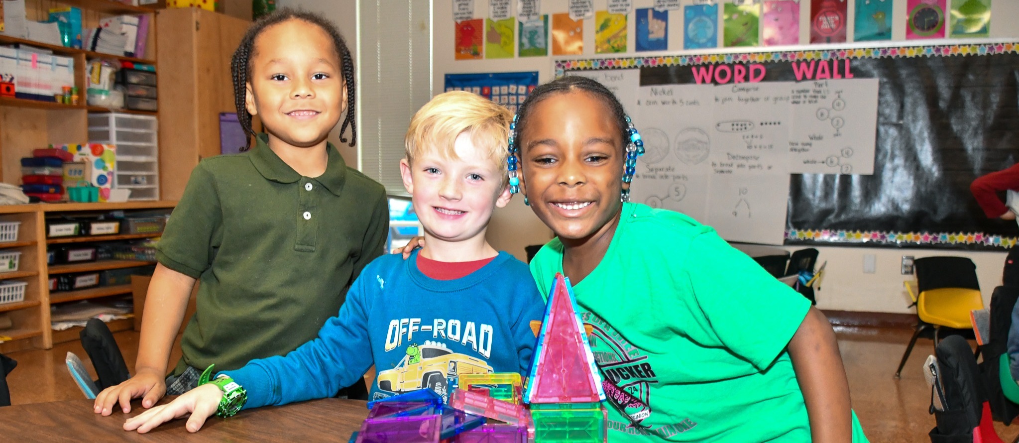 Three students smiling while playing