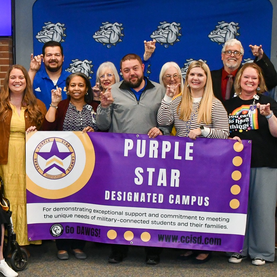 A group of people holding a banner in front of a backdrop