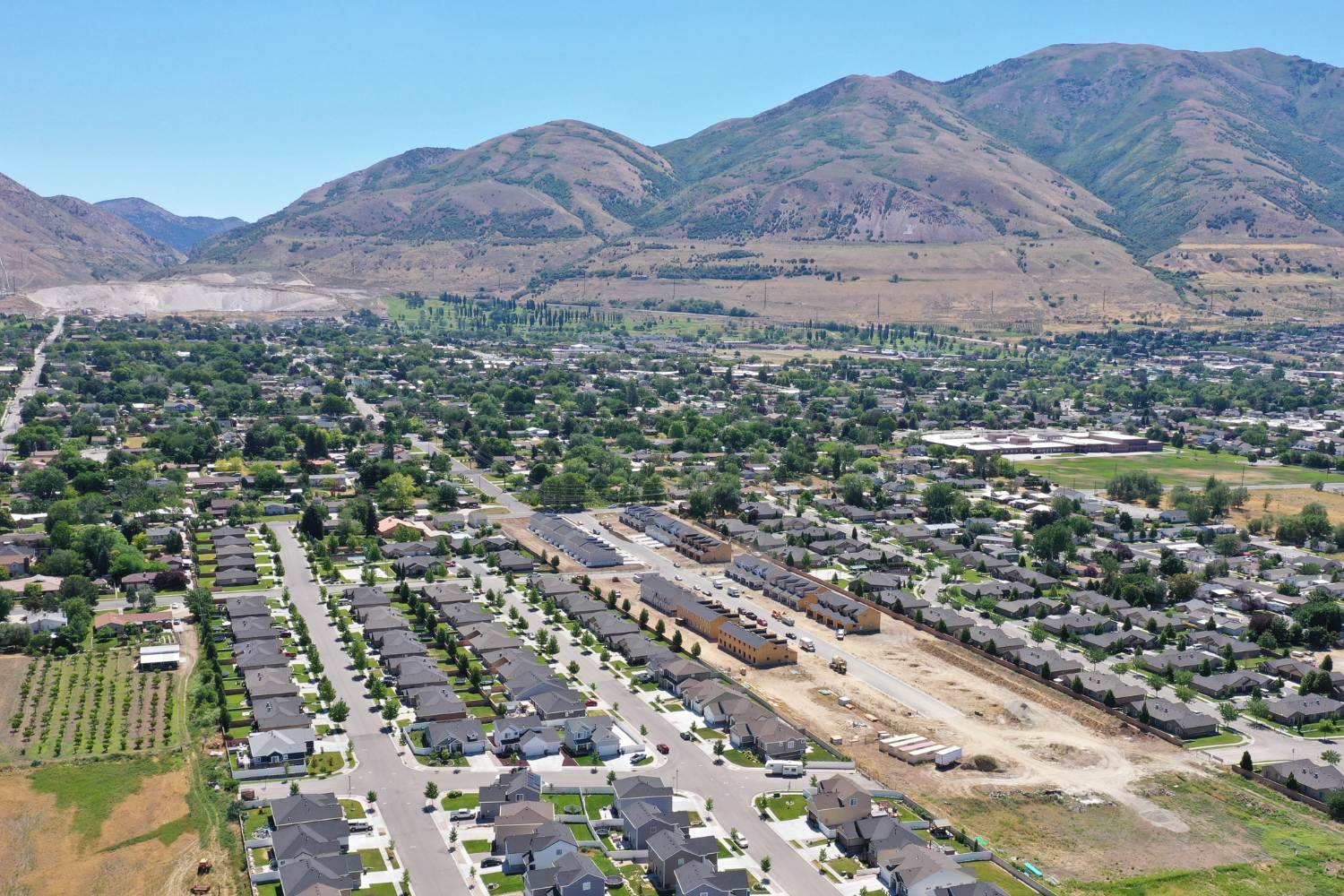 rows of homes and other buildings in front of mountains