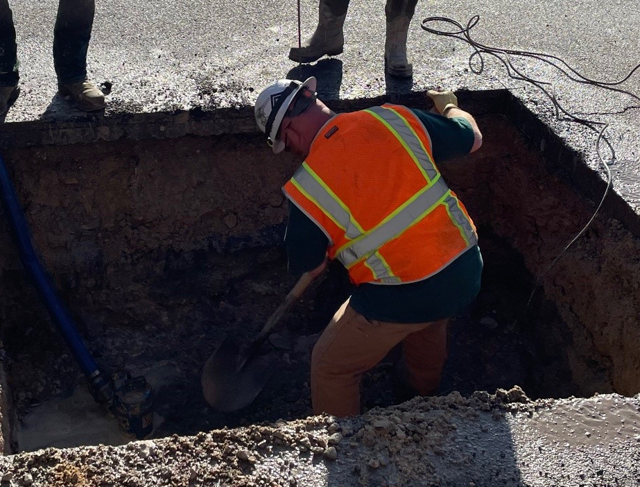 Employee fixing a water repair in the road