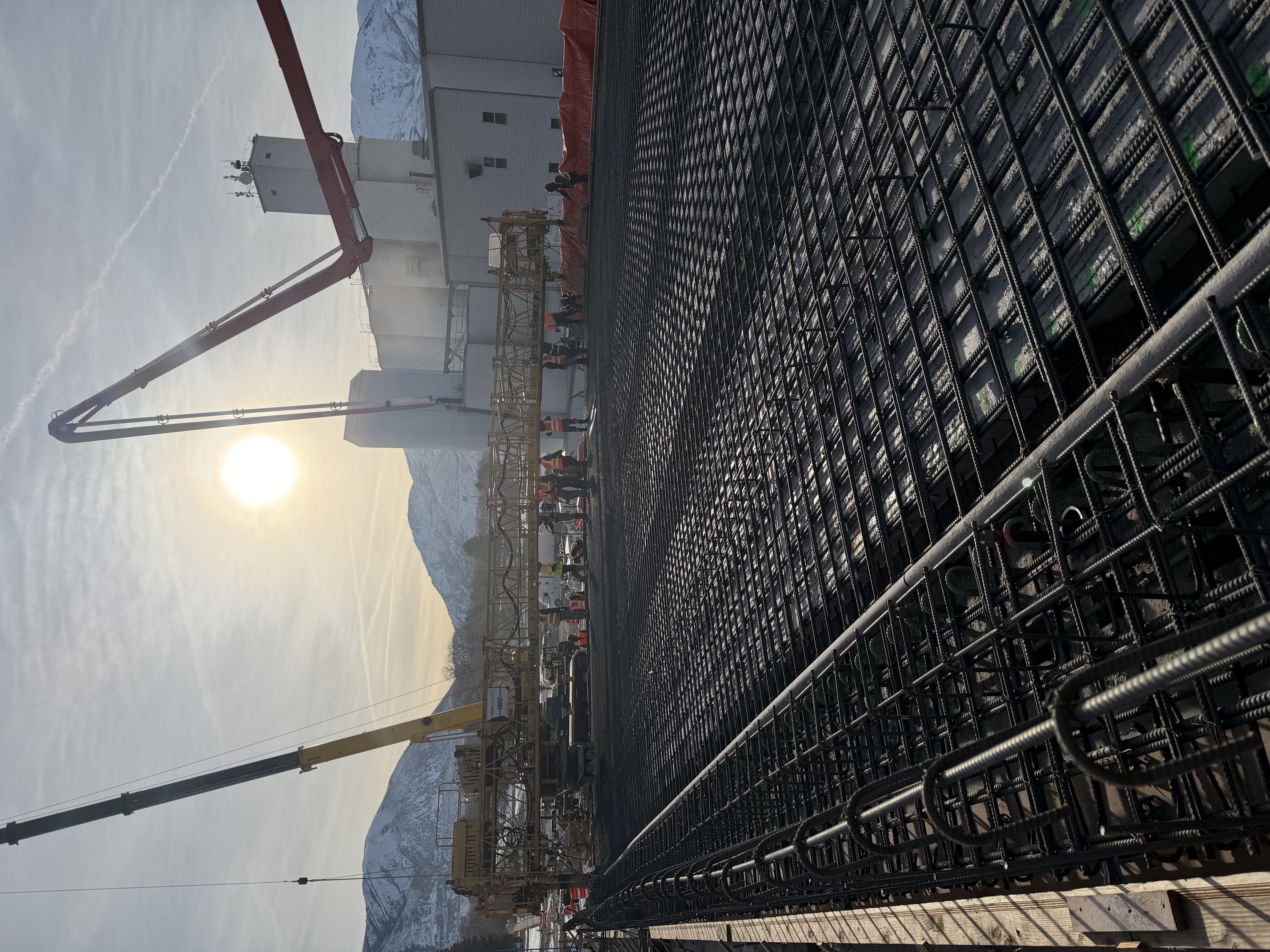 The sun rises over grids of rebar in the overpass