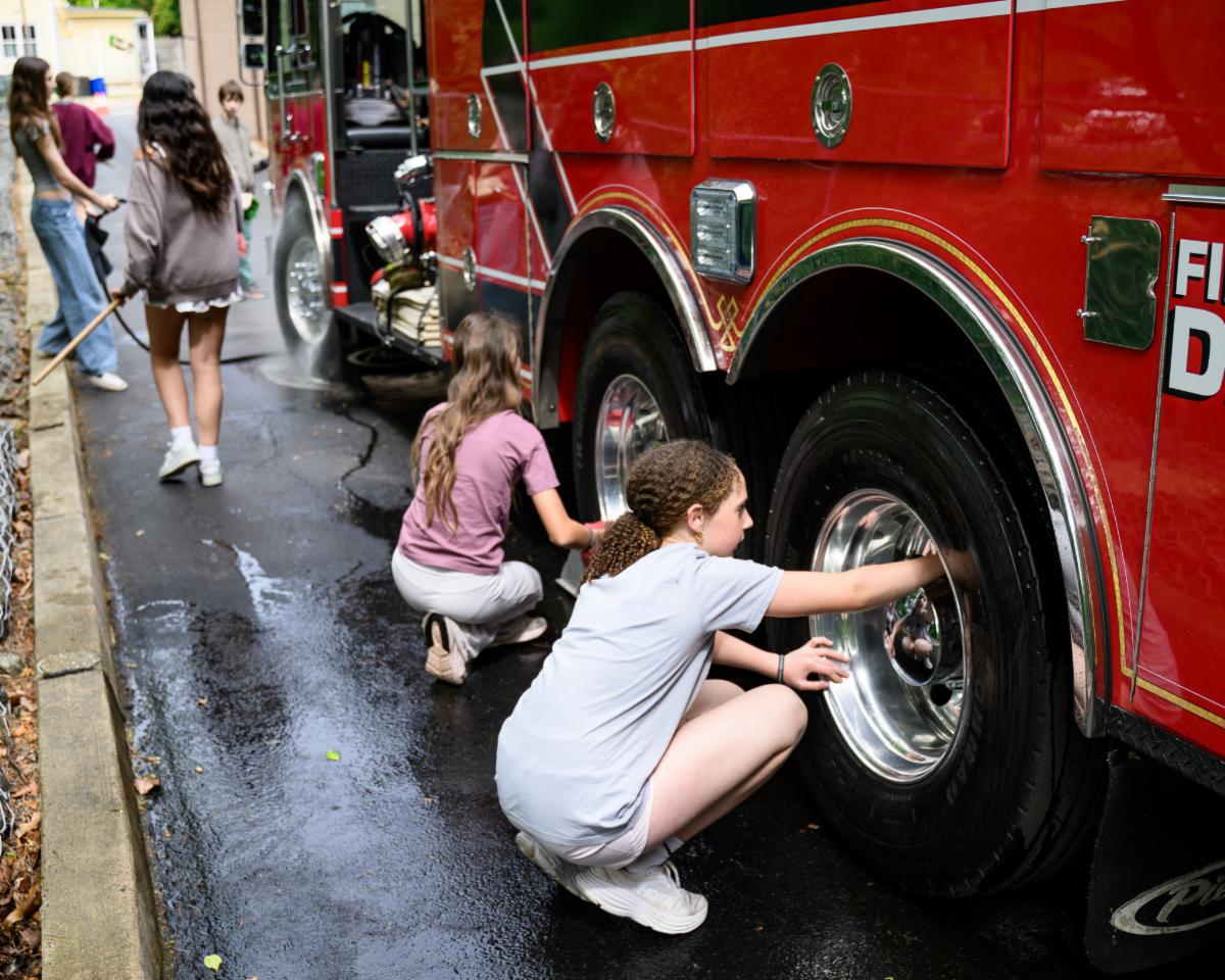 Middle School Students helping wash a firetruck during the Day of Giving