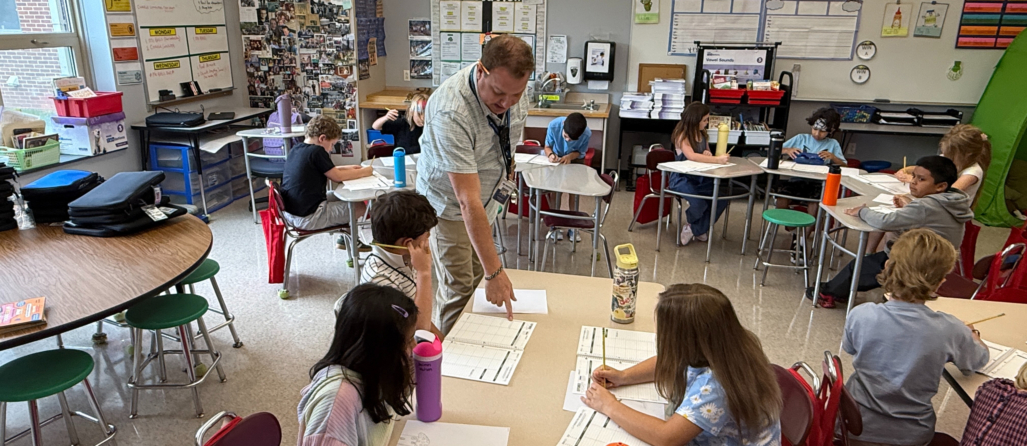 Teacher helping student at desk in classroom