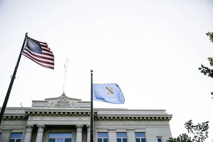 Picture of the top of the noble county with two flags