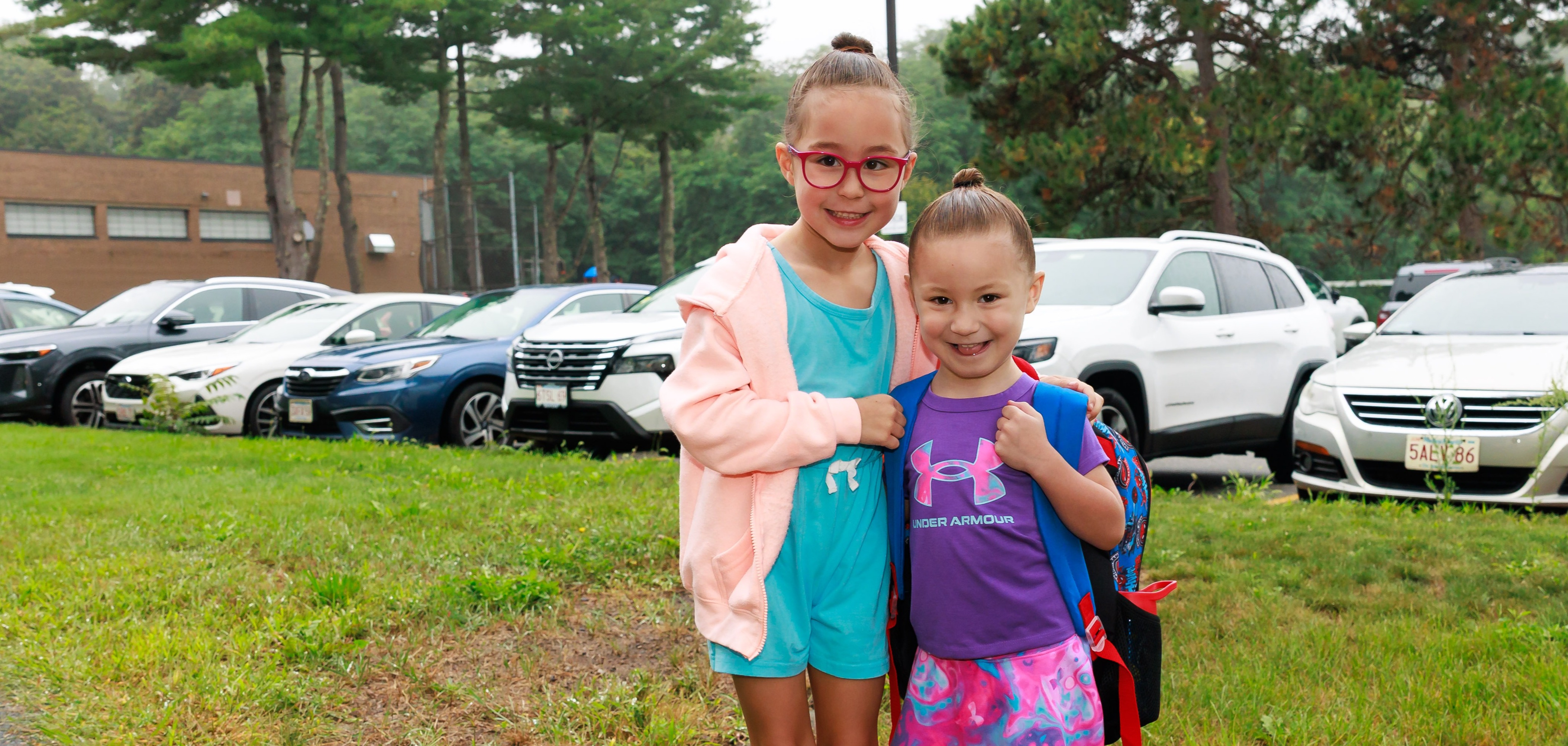 Two young students stand together on the first day of school.