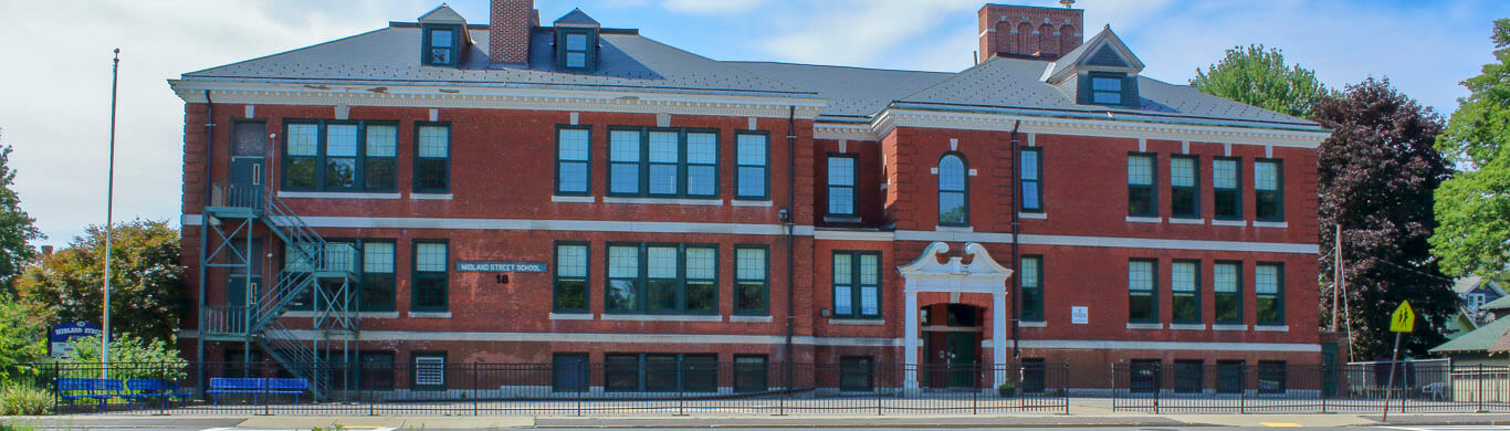 Midland street 3 story red brick school building green windows view from the street