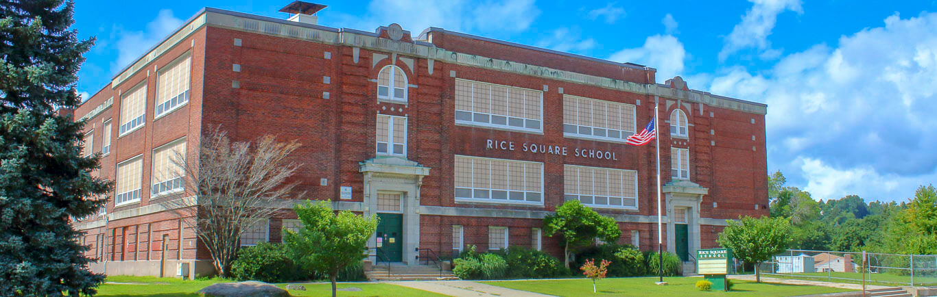 Rice Square School building with 3 stories and green doors facing the street