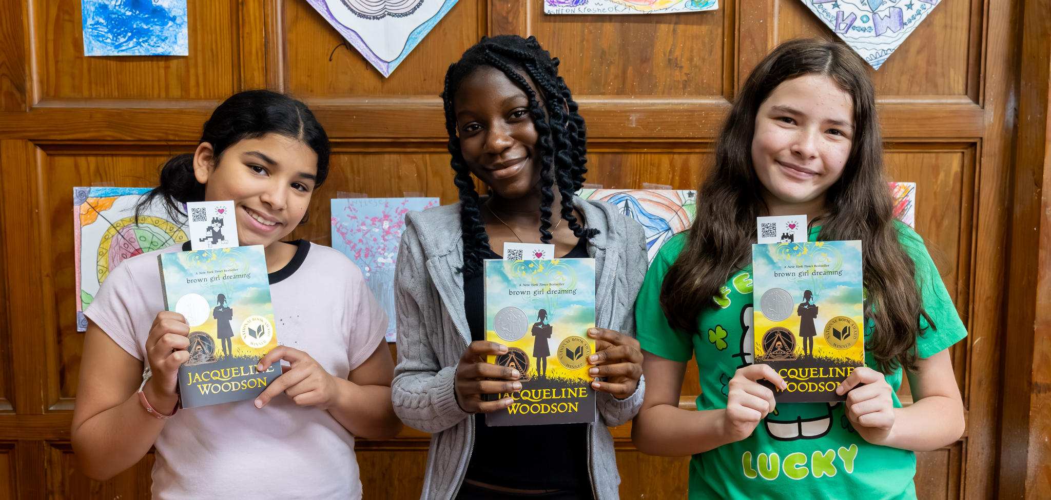 Three Vernon Hill students hold up books.
