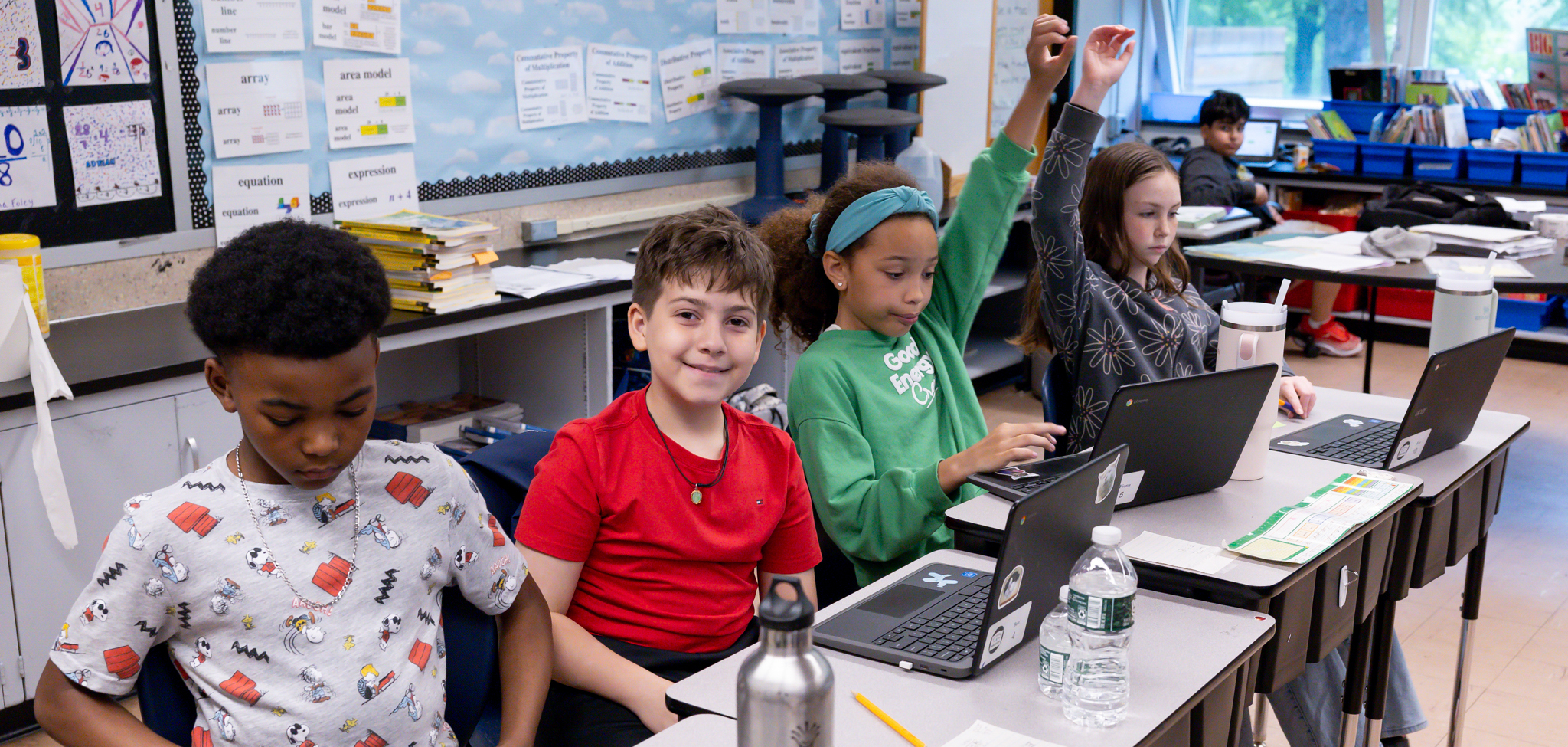 Four students at their desks during class.