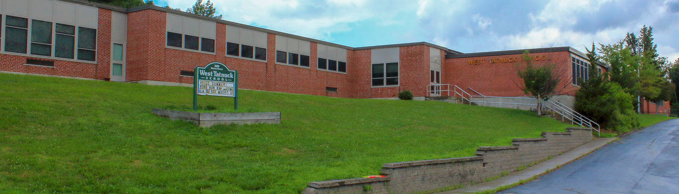 West Tatnuck view of building from down a green hill towards their school entrance and staircase 