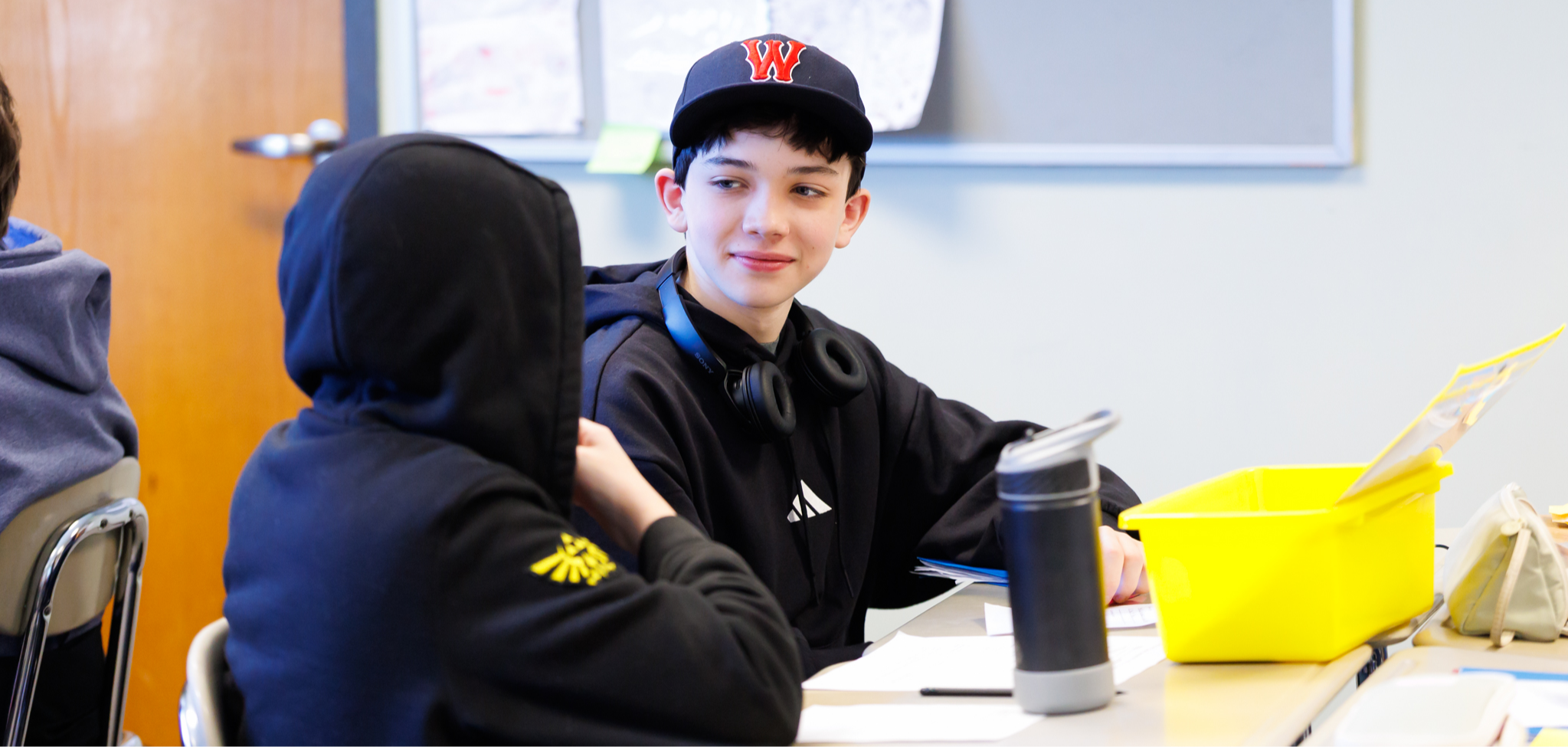 A student smiles while conversing with a classmate.