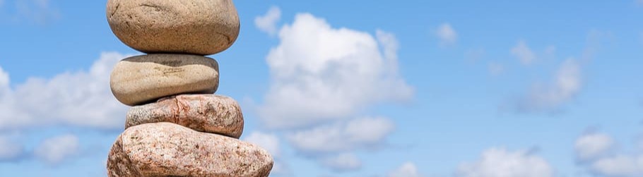 Rocks piled at the shore, blue sky on the background