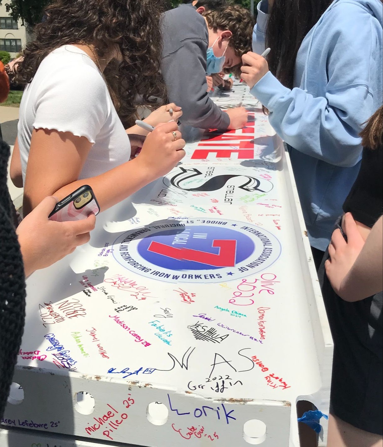 Student signing a beam for the new building