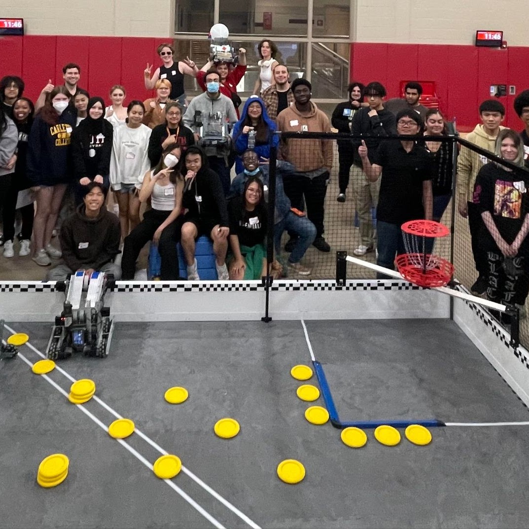 A large group of students watch a robotics competition