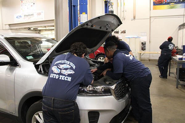 Students working on customer and training vehicles in Automotive Technology program