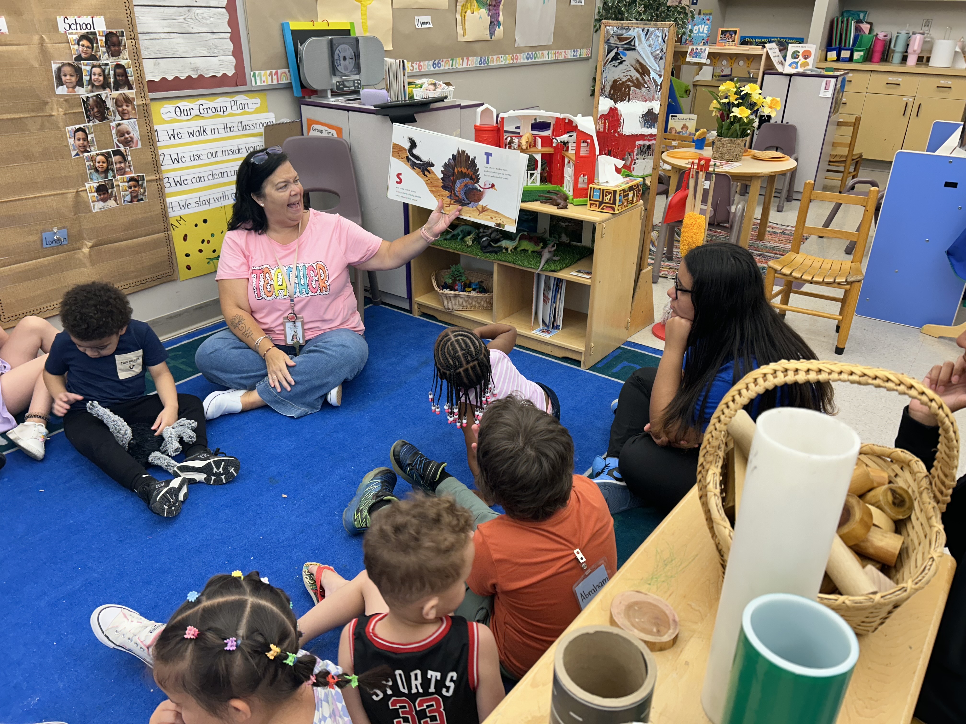 women reading a book to a group of children