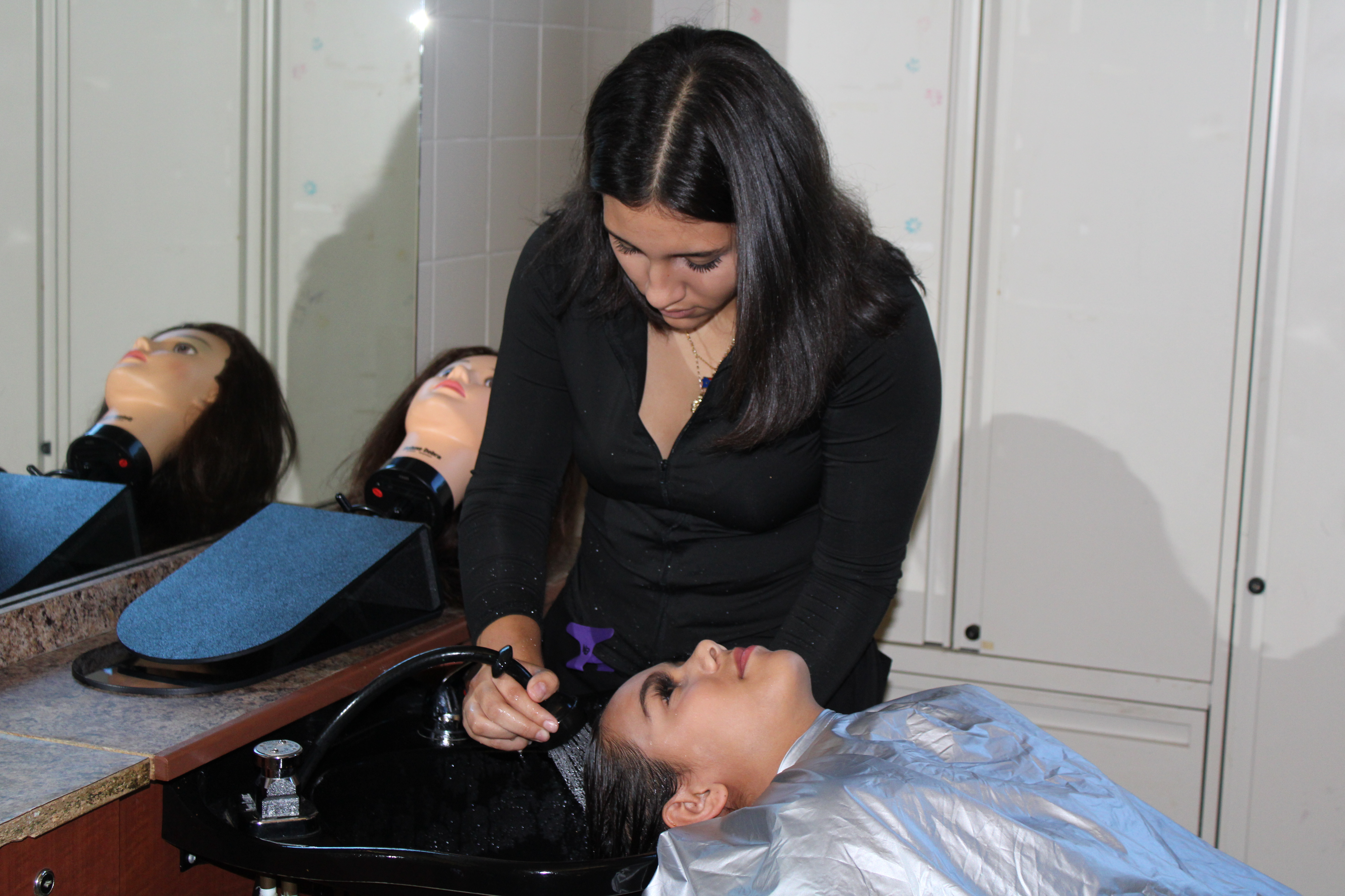 Girl washing other girls hair in the salon.