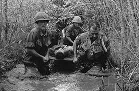 Picture of war, were soldiers are carrying an injured soldier down the river.